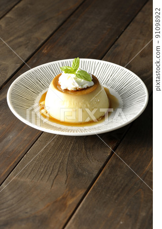 Old-fashioned retro pudding with mint leaves and fresh cream served on a flat plate 91098922