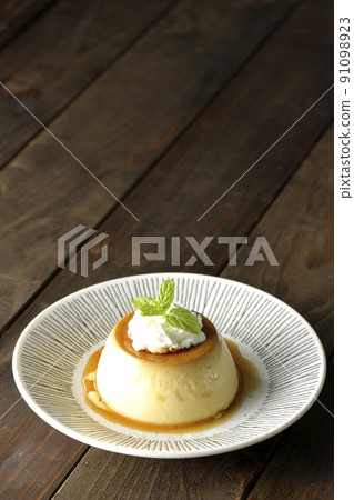 Old-fashioned retro pudding with mint leaves and fresh cream served on a flat plate Old-fashioned retro pudding with mint leaves and fresh cream served on a flat plate 91098923