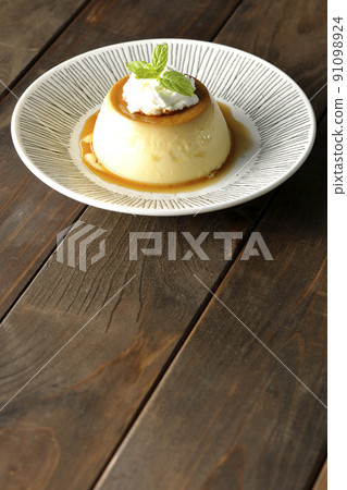 Old-fashioned retro pudding with mint leaves and fresh cream served on a flat plate 91098924
