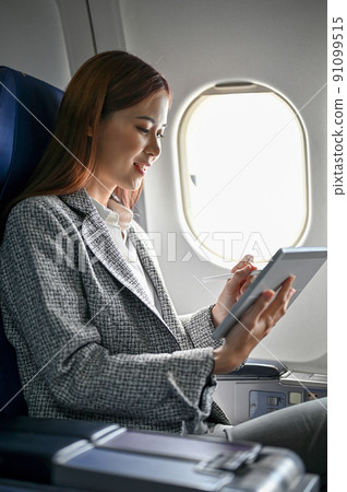 Beautiful asian businesswoman using a tablet during the flight. rear view 91099515