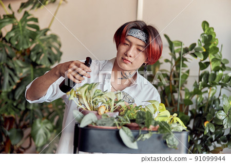 Smiling man holding spray bottle at home Smiling man holding spray bottle at home 91099944