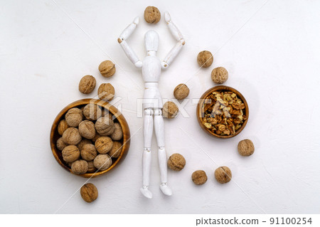 The human brain is shaped like a walnut kernel. Wooden mannequin with walnuts white background 91100254