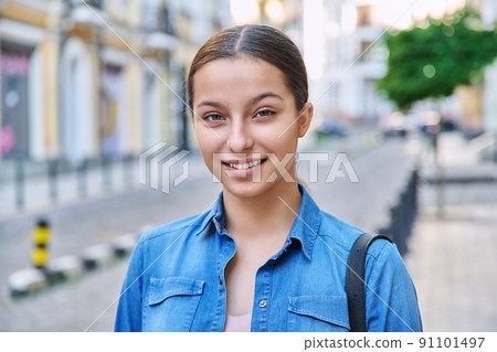 Headshot portrait of positive teenage young female looking at camera 91101497