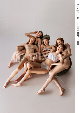 Portrait of beautiful tender women posing together isolated over grey studio background. Models posing in underwear. Portrait of beautiful tender women posing together isolated over grey studio background. Models posing in underwear. 91101683