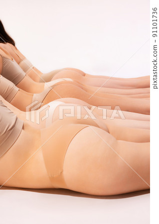 Image of slender, smooth female buttocks in beige underwear isolated over grey studio background. Anti-cellulite treatment 91101736