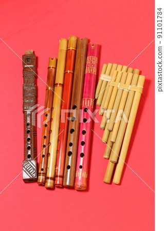 Latin American folk instrument, quena and seek, red background 91101784