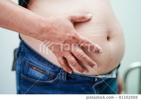 Asian woman show fat belly big size overweight and obesity at office. 91102008