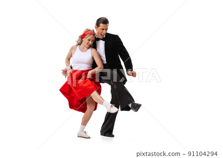 Excited young couple of dancers in vintage retro style outfits dancing social dance isolated on white background. Art, music, fashion, style concept Excited young couple of dancers in vintage retro style outfits dancing social dance isolated on white background. Art, music, fashion, style concept 91104294