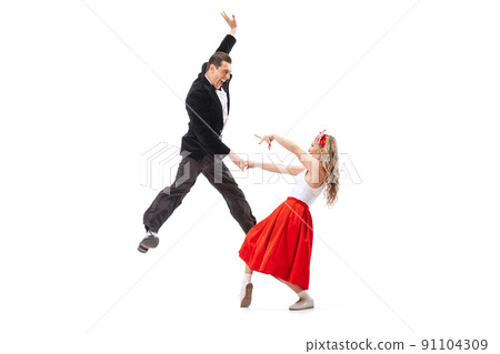 Astonished young man and woman in retro style outfits dancing lindy hop isolated on white background. Art, music, fashion, style concept 91104309