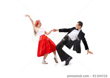 Expressive couple of dancers in vintage retro style outfits dancing social dance isolated on white background. Art, music, fashion, style concept 91104310