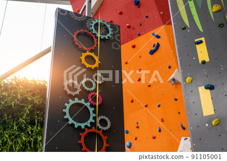 Indoor bouldering and climbing wall for training at modern gym. Gears and toy climbing wall for children Indoor bouldering and climbing wall for training at modern gym. Gears and toy climbing wall for children 91105001