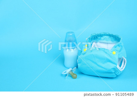 Concept of baby clothes with reusable diapers on blue background 91105489