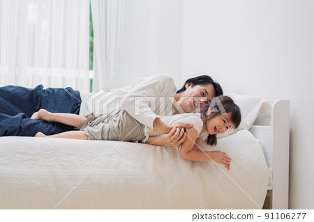 Little girl playing in bed with dad 91106277