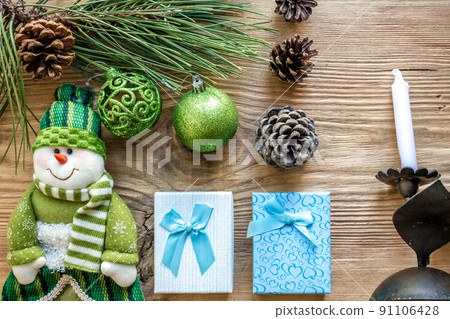 Christmas decoration. Branch christmas tree and cones spruce, antique candlestick, candles, glass balls on wooden background. Christmas decoration. Branch christmas tree and cones spruce, antique candlestick, candles, glass balls on wooden background. 91106428
