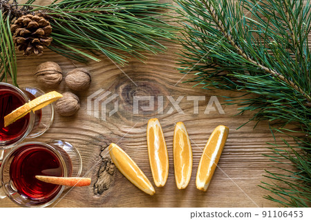 Two glass of mulled wine with cinnamon sticks, slice of oranges and apple, star anise on a wooden table 91106453