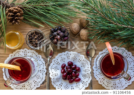 Two glass of mulled wine with cinnamon sticks, slice of oranges and apple, star anise on a wooden table 91106456