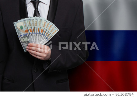 Business man with 100 US dollar bills money banknotes against flag of Russia background Business man with 100 US dollar bills money banknotes against flag of Russia background 91108794