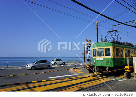 Enoden 300 type going to the railroad crossing in front of Kamakura High School under a clear sky Enoden 300 type going to the railroad crossing in front of Kamakura High School under a clear sky 91109159