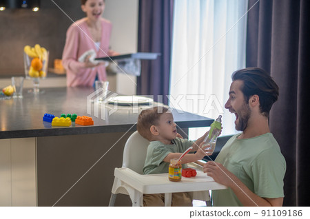 Dad, mom and a small son in the kitchen at home 91109186