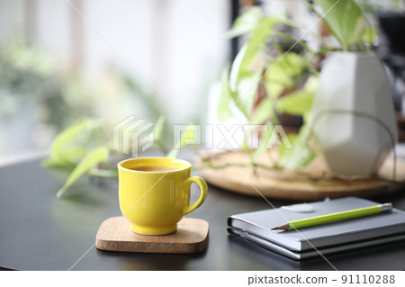 Yellow coffee cup and notebook and plant pot Yellow coffee cup and notebook and plant pot 91110288