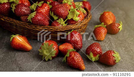 Ripe juicy strawberries in a basket on a dark background. Close up. Ripe juicy strawberries in a basket on a dark background. Close up. 91110291