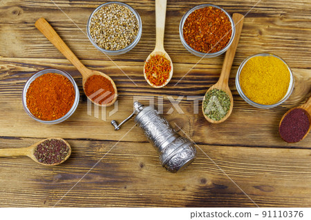 Set of different aromatic spices and spice mill on wooden table. Top view 91110376