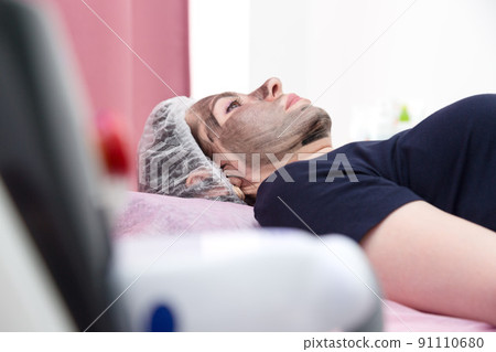 An adult woman is lying on the couch waiting for the start of the carbon peeling procedure An adult woman is lying on the couch waiting for the start of the carbon peeling procedure 91110680