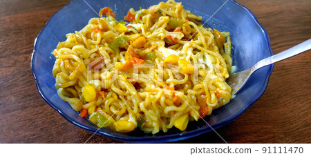 Corn maggie noodles, Instant Noodle served in blue bowl on wooden background. Selective focus. 91111470