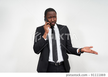 Closeup of angry young african man screaming while talking on smartphone over grey background 91111869