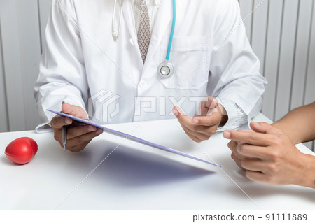 A doctor consults patient while sitting at the table in office. Medicine and health care concept. A doctor consults patient while sitting at the table in office. Medicine and health care concept. 91111889