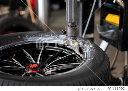Wheel with tire on tire changing machine in auto repair service. Wheel with tire on tire changing machine in auto repair service. 91111902