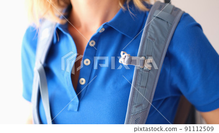 Backpack hanging on shoulders of woman in blue t-shirt closeup Backpack hanging on shoulders of woman in blue t-shirt closeup 91112509