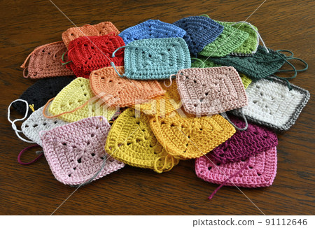 colorful knitted squares on the wooden background 91112646