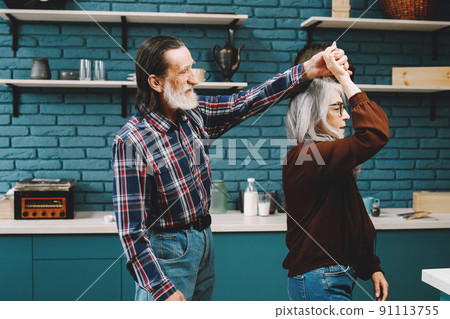 Happy senior couple. Older people dancing when cooking in kitchen. 91113755