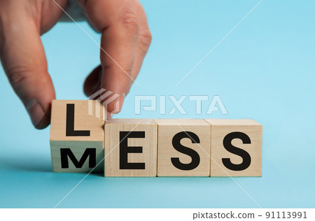 Less mess words on wooden blocks. Turned the cube and changed the word mess to less. Blue background Less mess words on wooden blocks. Turned the cube and changed the word mess to less. Blue background 91113991