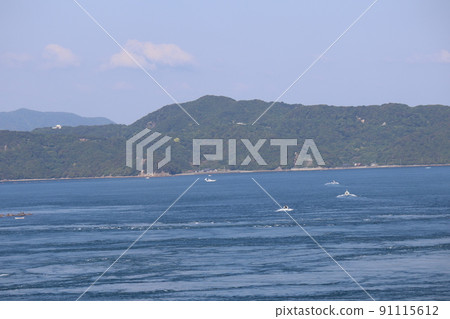 A landscape of the blue sea surface where fishing boats come and go, the coastline roads, the peninsula where you can see the town, the mountains, the clouds and the blue sky A landscape of the blue sea surface where fishing boats come and go, the coastline roads, the peninsula where you can see the town, the mountains, the clouds and the blue sky 91115612