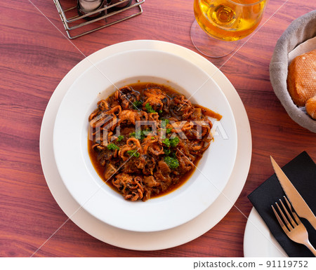 Popular Spanish dish is octopus with onions 91119752