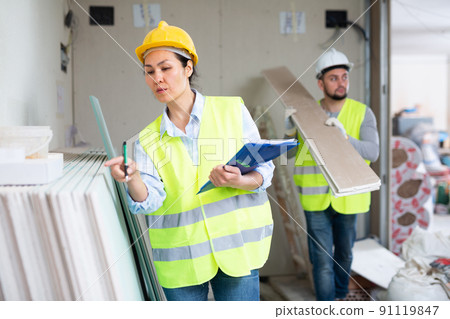Female building inspector taking inventory of materials at construction site 91119847