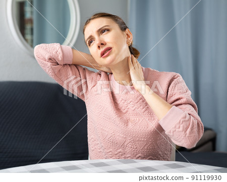 Young woman experiencing neck pain 91119930