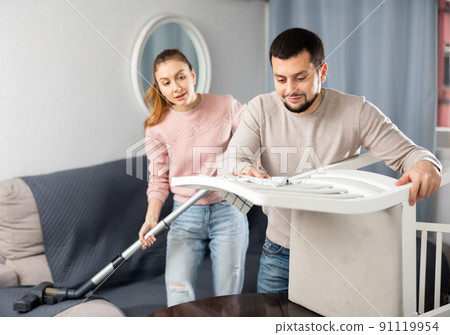 Young couple cleaning table in living room 91119954
