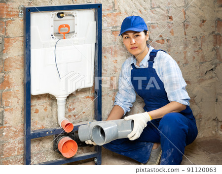 Plumber installing back to wall toilet system Plumber installing back to wall toilet system 91120063