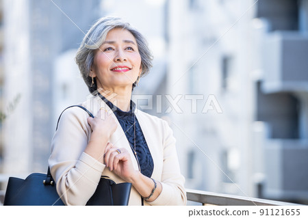 Middle woman standing with a bag in the business district Middle woman standing with a bag in the business district 91121655