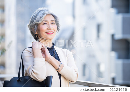 Middle woman standing with a bag in the business district Middle woman standing with a bag in the business district 91121656