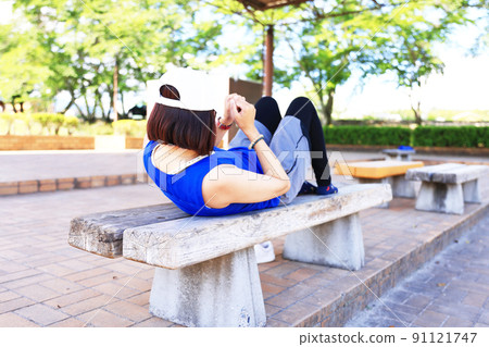 Woman stretching on the bench Woman stretching on the bench 91121747