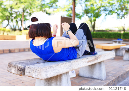 Woman stretching on the bench Woman stretching on the bench 91121748