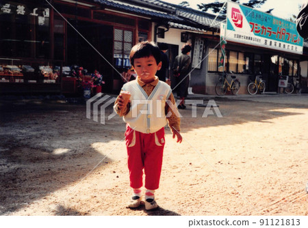 A little boy eating ice cream, an old film photo 91121813
