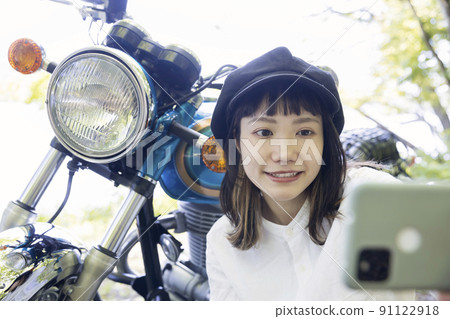 騎自行車的女孩形象與摩托車合影的年輕女子 騎自行車的女孩形象與摩托車合影的年輕女子 91122918