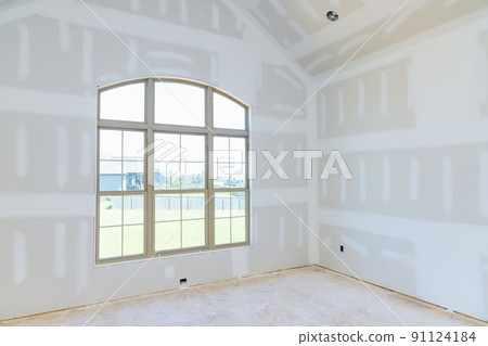 In an empty apartment room renovating a new house under construction, we are finishing the walls with putty In an empty apartment room renovating a new house under construction, we are finishing the walls with putty 91124184