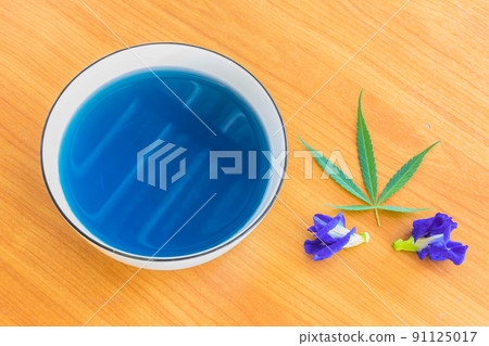 Cannabis ,Marijuana and Blue Pea, herb hot tea on the bowl with Cannabis leaf and Blue Pea flower. Cannabis ,Marijuana and Blue Pea, herb hot tea on the bowl with Cannabis leaf and Blue Pea flower. 91125017