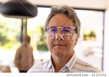 Close-up portrait of serious caucasian senior man wearing eyeglasses contemplating in nursing home 91125332